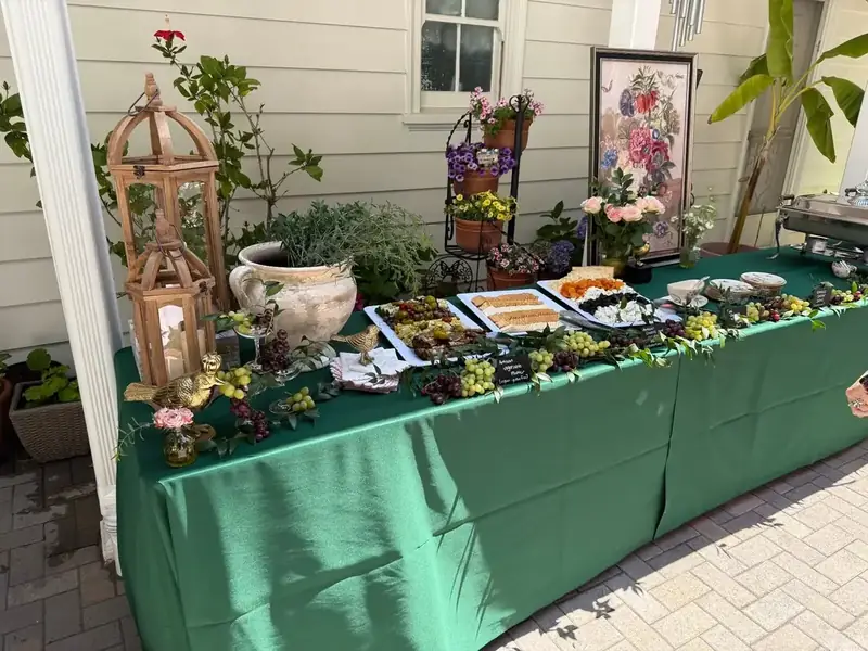 Marin Catering Company’s elegant outdoor appetizer station styled with greenery, garden florals, fruit, and curated savory bites.